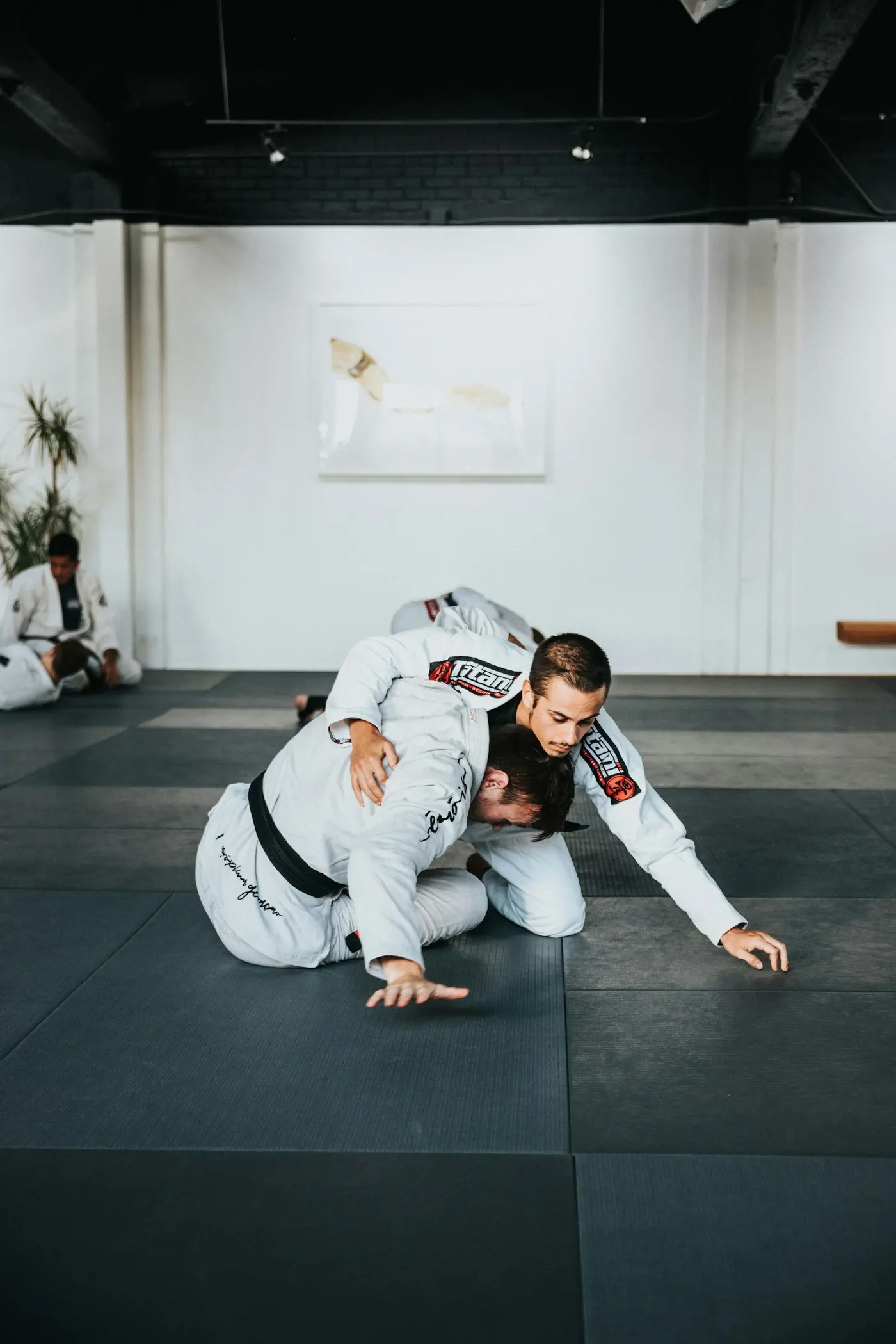 Two grapplers in white gis drilling on the mats