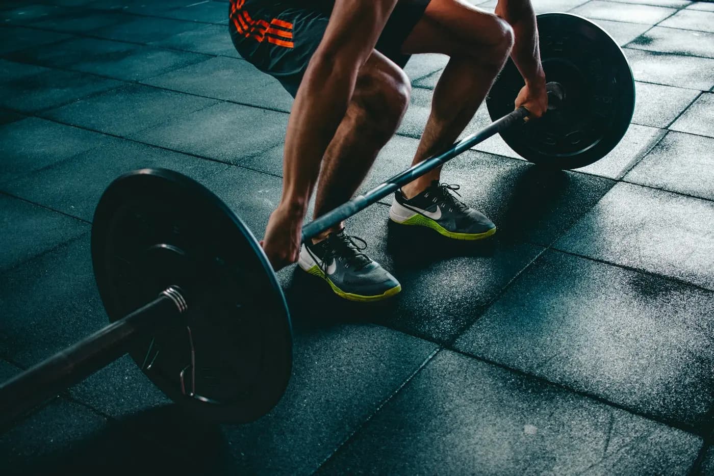 A lifter setting up over a barbell on a rubber gym floor